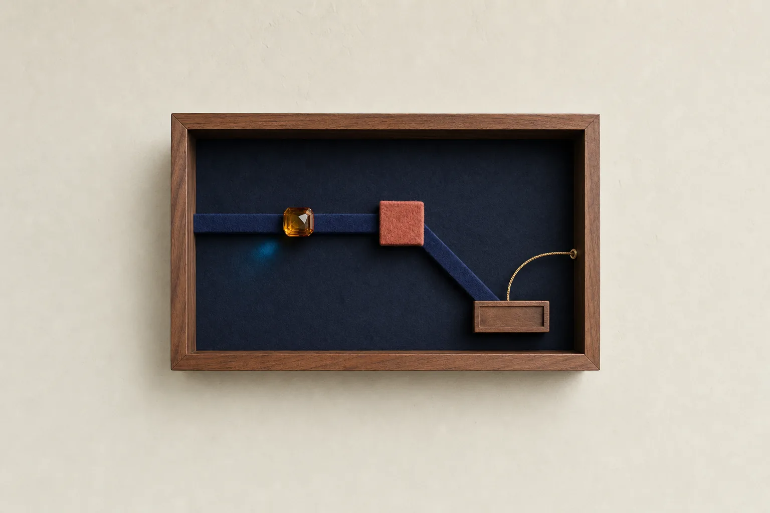 An amber glass bead redirects through a felt groove inside one clearly bounded walnut shadow box.