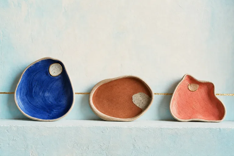 Three irregular vessels each hold one dominant colored field and a smaller contrasting inset.